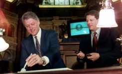 President Bill Clinton uses an electronic pen to sign the Telecommunications Reform Act in 1996