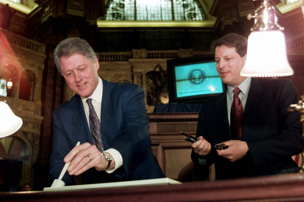 President Bill Clinton uses an electronic pen to sign the Telecommunications Reform Act in 1996